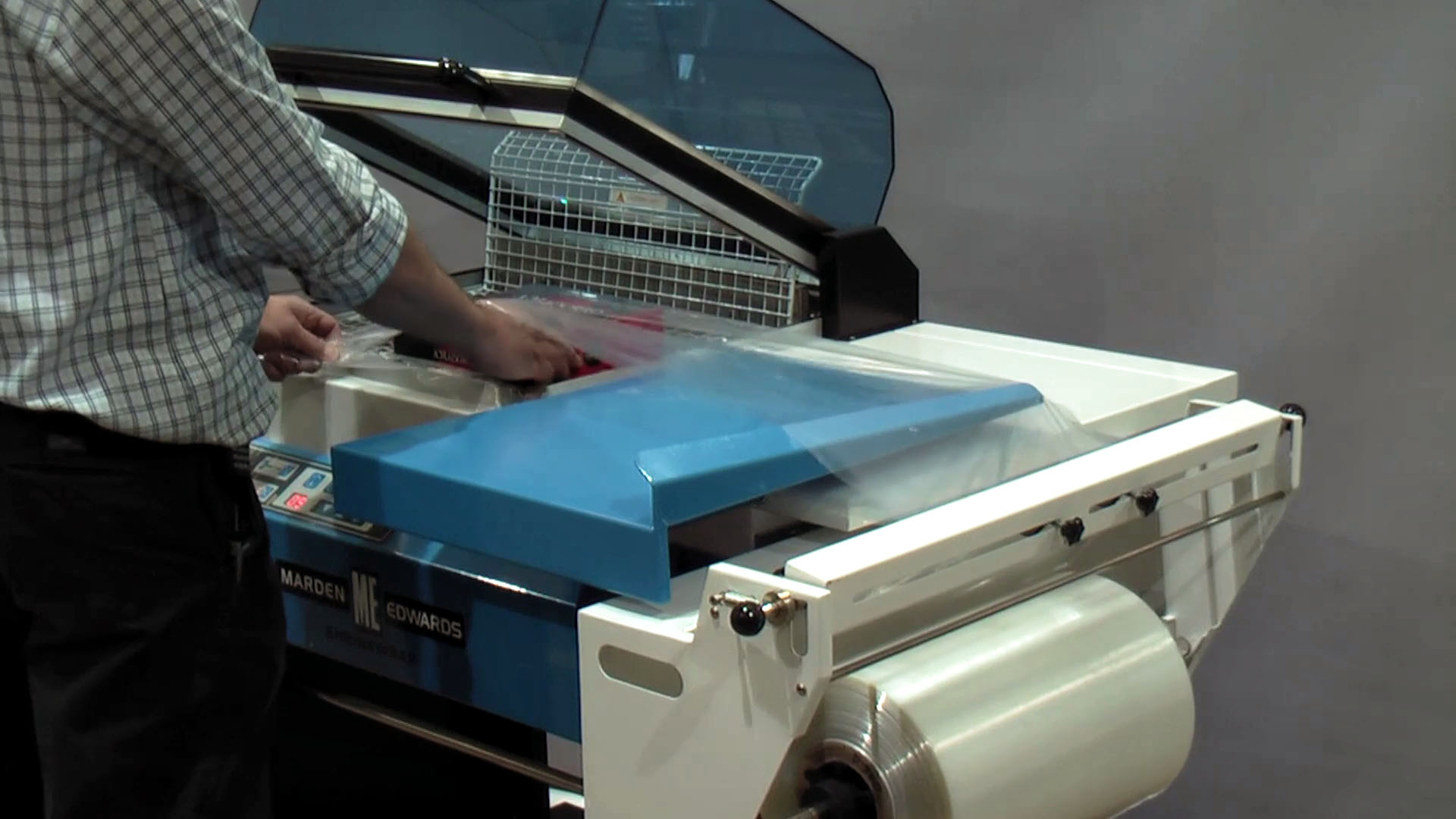 Person using a chamber shrink wrapping machine